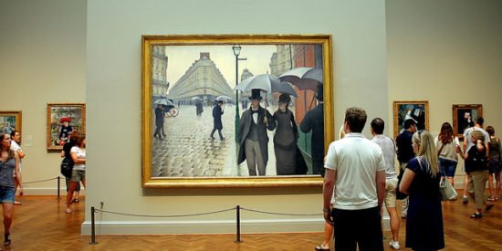 People viewing 'Paris Street; Rainy Day, 1877' by Gustave Caillebotte.